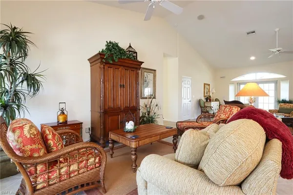 a living room with furniture a lamp and a potted plant