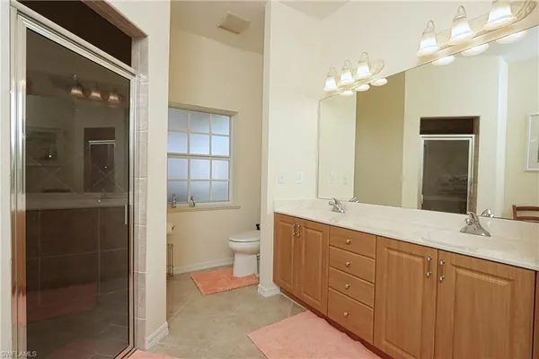 a spacious bathroom with a granite countertop sink toilet and shower