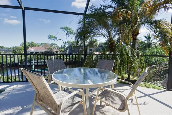 a roof deck with table and chairs potted plants with wooden floor