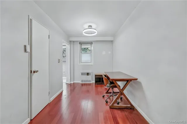 a view of a room with wooden floor air conditioner and a window