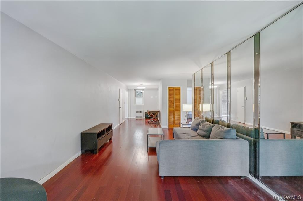 35-11 85th Street, Unit 3H Queens, NY 11372 - Photo 18 of 27 a living room with furniture wooden floor and a large window