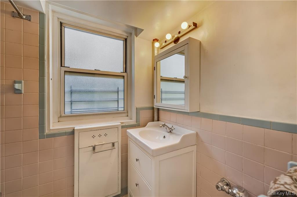35-11 85th Street, Unit 3H Queens, NY 11372 - Photo 7 of 27 a bathroom with a sink mirror and vanity