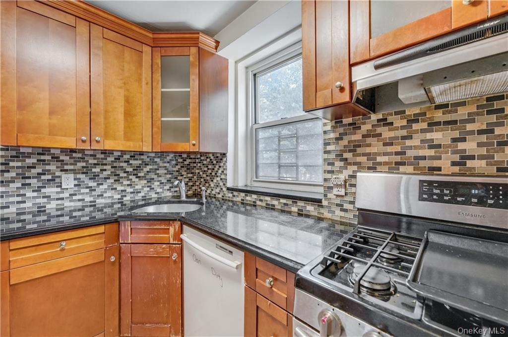 35-11 85th Street, Unit 3H Queens, NY 11372 - Photo 9 of 27 a kitchen with granite countertop a sink stove and cabinets