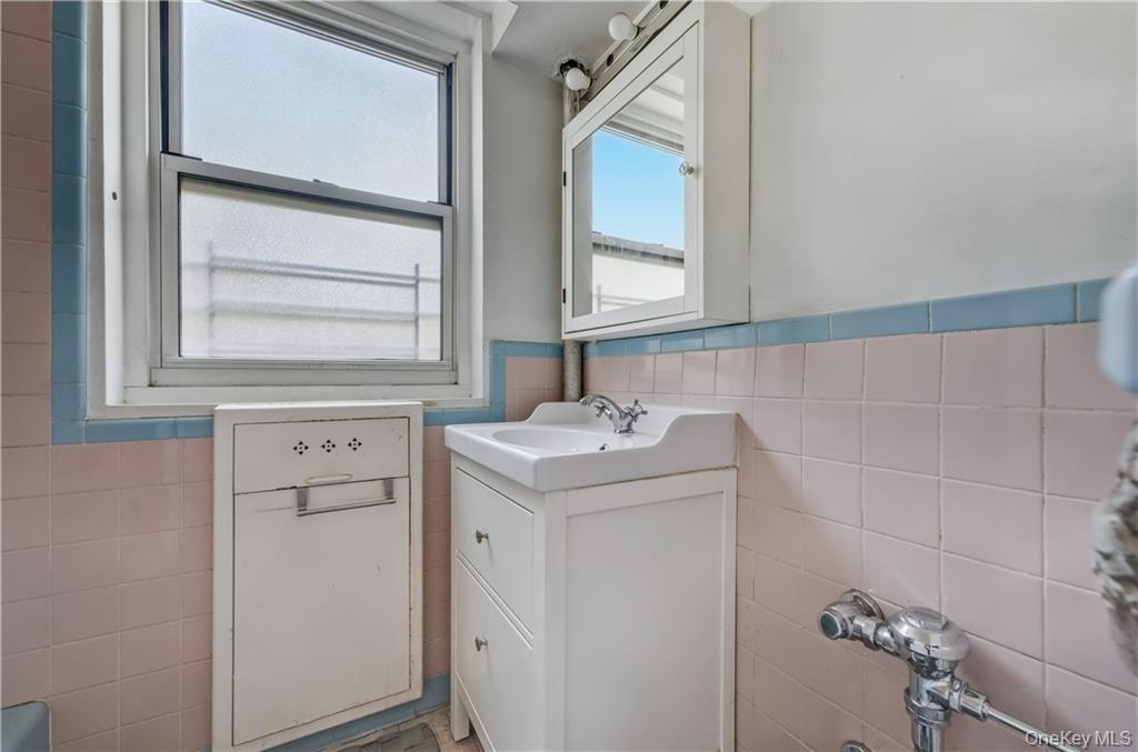 35-11 85th Street, Unit 3H Queens, NY 11372 - Photo 10 of 27 a bathroom with a sink a vanity and a mirror