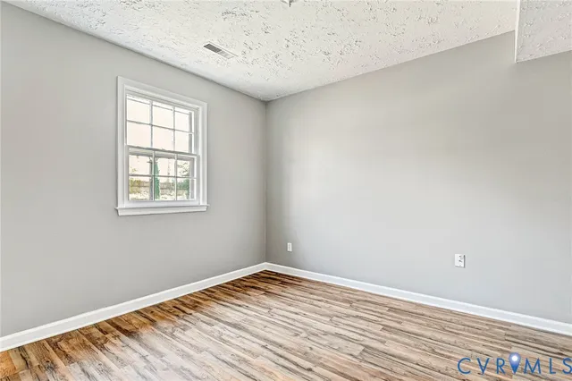 wooden floor in an empty room with a fireplace
