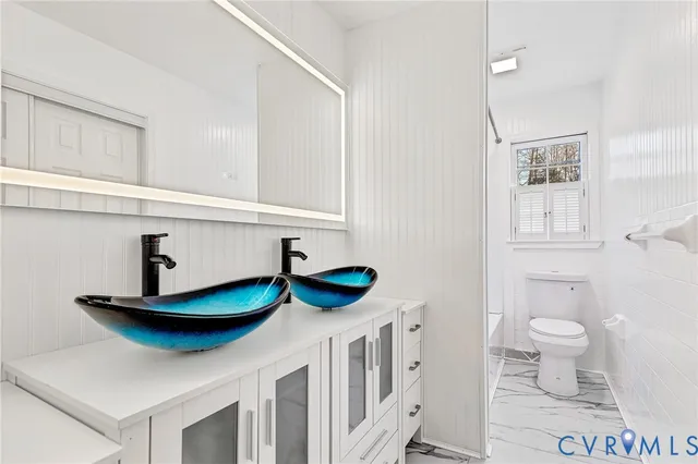 a kitchen with stainless steel appliances a sink a stove and white cabinets
