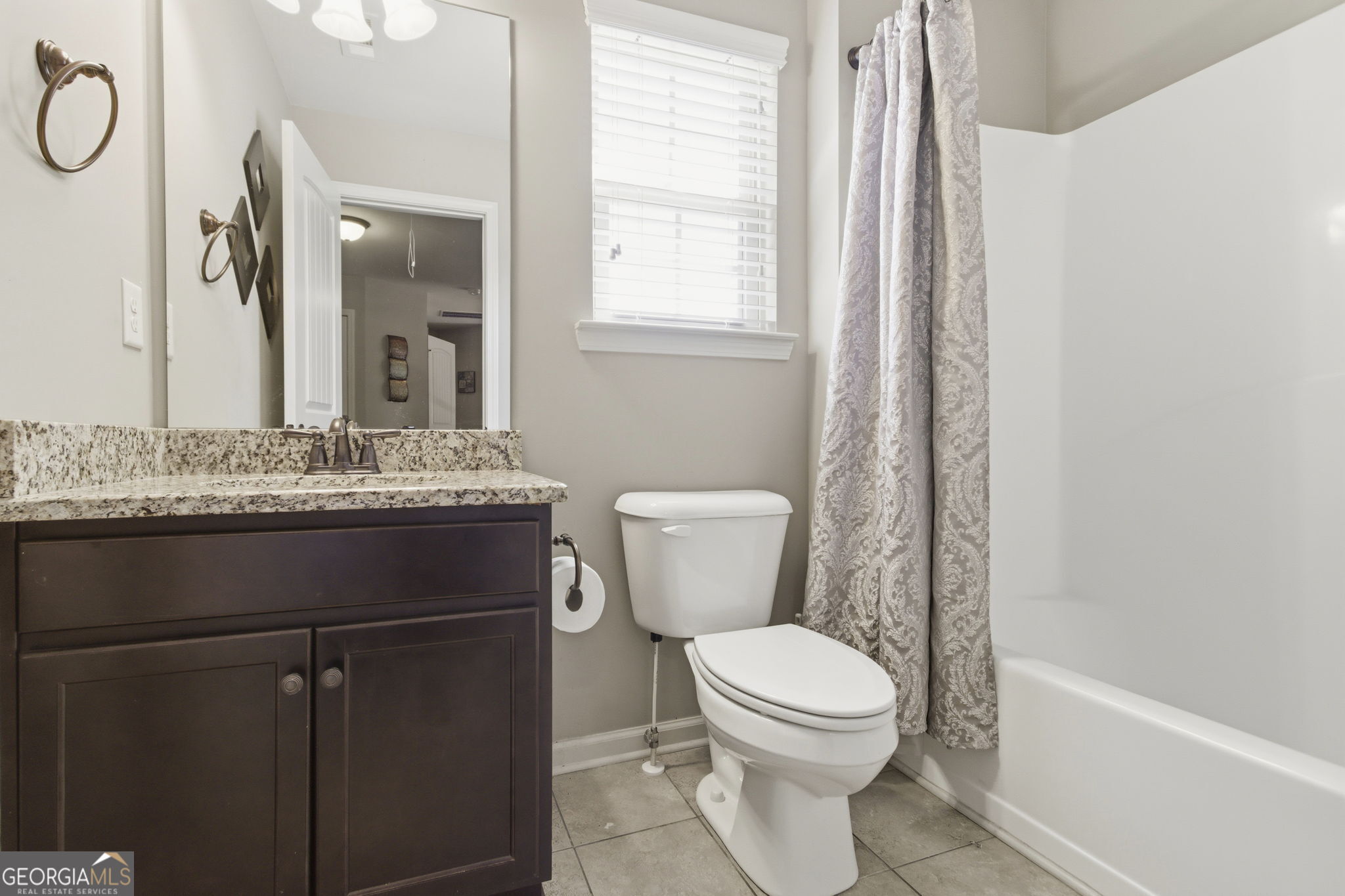 127 Austin Storey Circle Newnan, GA 30263 - Photo 24 of 34 a bathroom with a granite countertop toilet sink and mirror