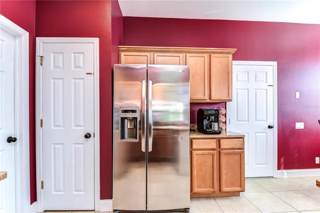 a kitchen with stainless steel appliances kitchen island granite countertop a refrigerator and a stove top oven