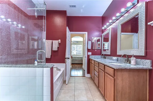 a bathroom with a granite countertop sink a vanity and a large mirror