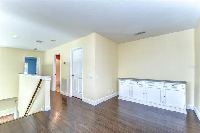 a view of an empty room with wooden floor