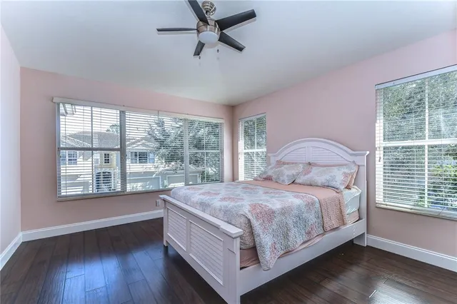 a bedroom with a bed wooden floor and window