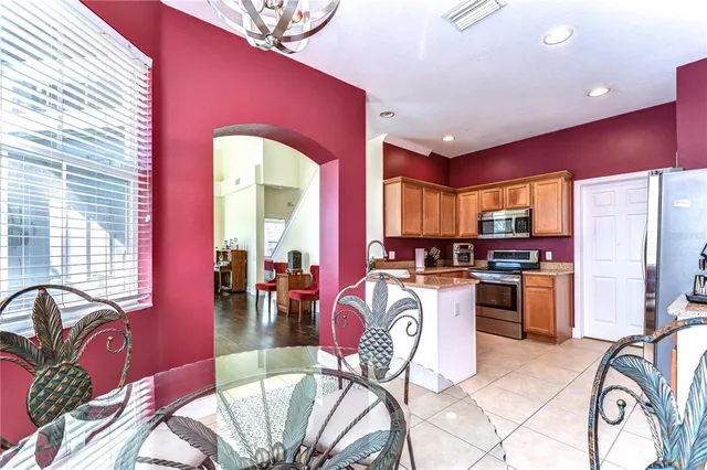 a kitchen with stainless steel appliances dining table a sink and a large window