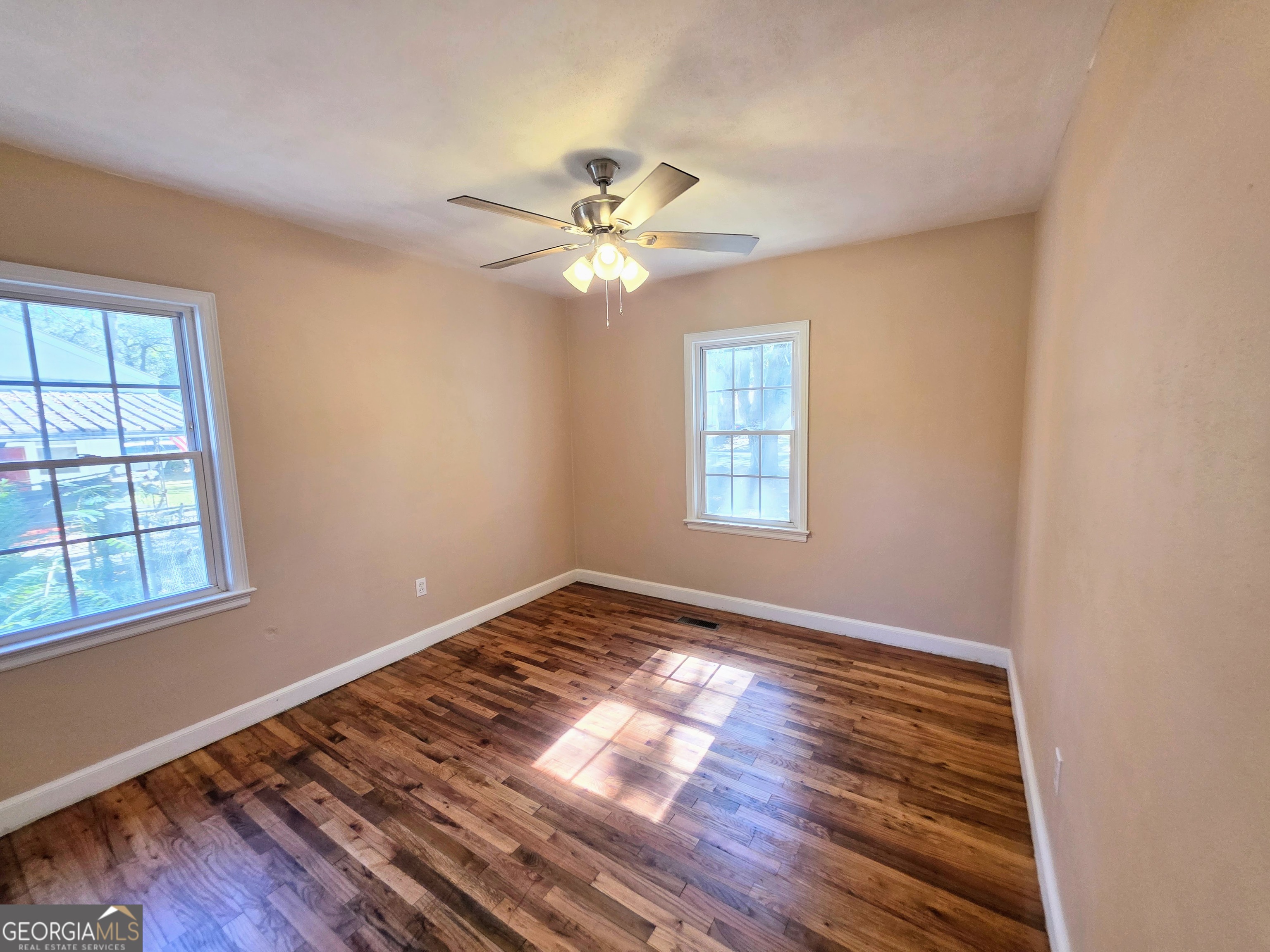 723 10th Avenue Albany, GA 31701 - Photo 11 of 23 wooden floor in an empty room with a window