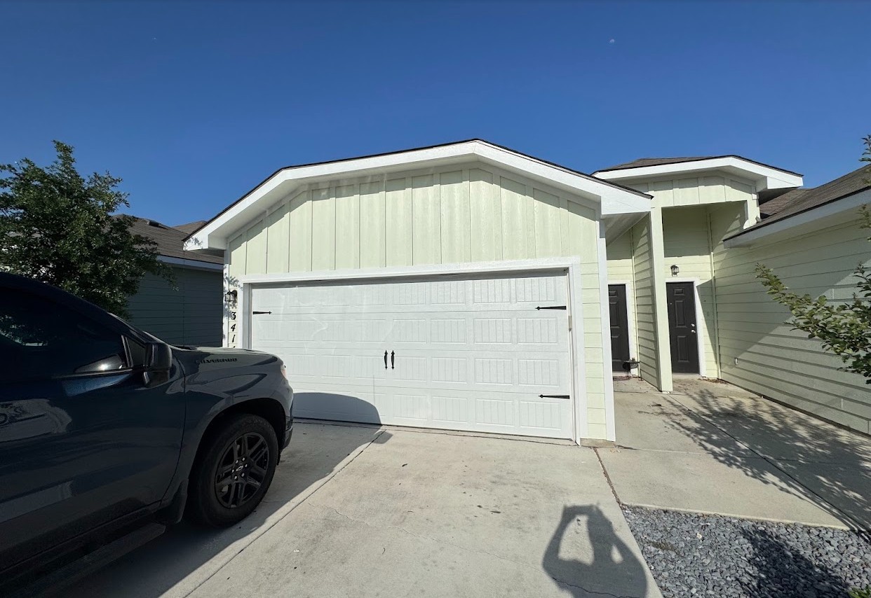 View of property exterior featuring board and batten siding, an attached garage, and concrete driveway