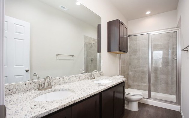 3414 Scott Circle Seguin, TX 78155 - Photo 11 of 12 Bathroom with double vanity, a stall shower, dark wood-style floors, and recessed lighting