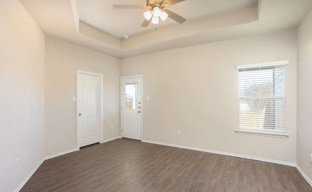 3414 Scott Circle Seguin, TX 78155 - Photo 10 of 12 Spare room with a raised ceiling, dark wood-style flooring, and a ceiling fan