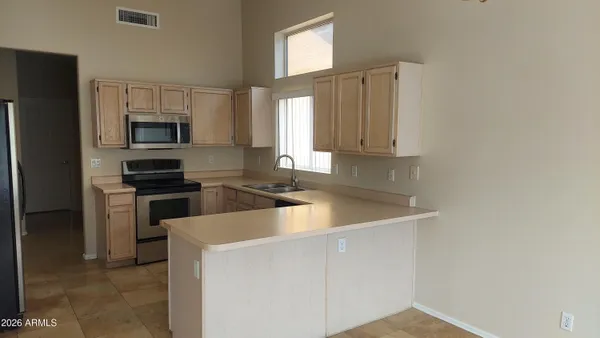 a kitchen with a sink and a stove top oven with wooden floor