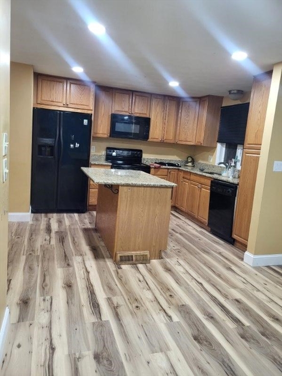 70 Broadway, Unit 24 North Attleboro, MA 02760 - Photo 1 of 10 a kitchen with stainless steel appliances granite countertop a refrigerator a sink dishwasher a stove and white countertops with wooden floor