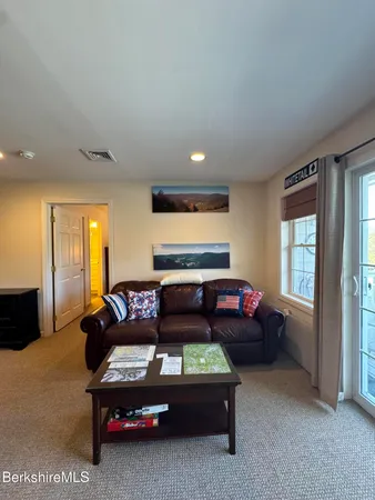 a bed sitting in a bedroom next to a window and dresser