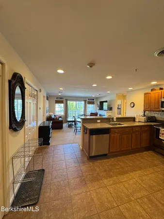 a large kitchen with stainless steel appliances granite countertop a sink and cabinets