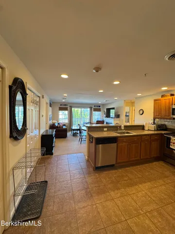 a large kitchen with stainless steel appliances granite countertop a sink and cabinets