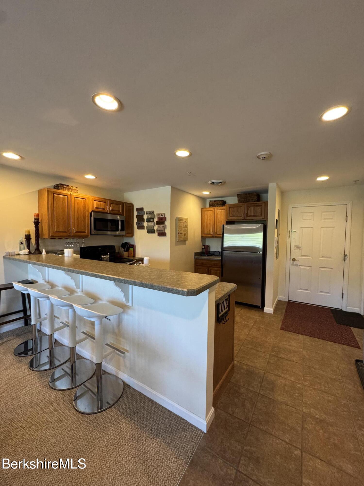 37 Corey Road, Unit 862 Hancock, MA 01237 - Photo 9 of 27 a kitchen with stainless steel appliances kitchen island granite countertop a sink and cabinets