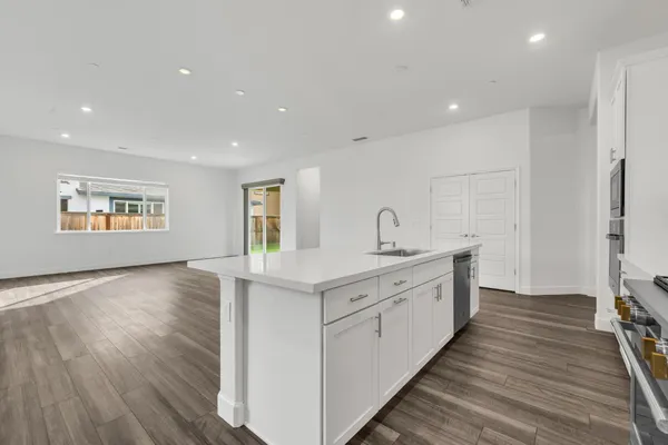 a large kitchen with stainless steel appliances granite countertop a lot of counter space and wooden floors