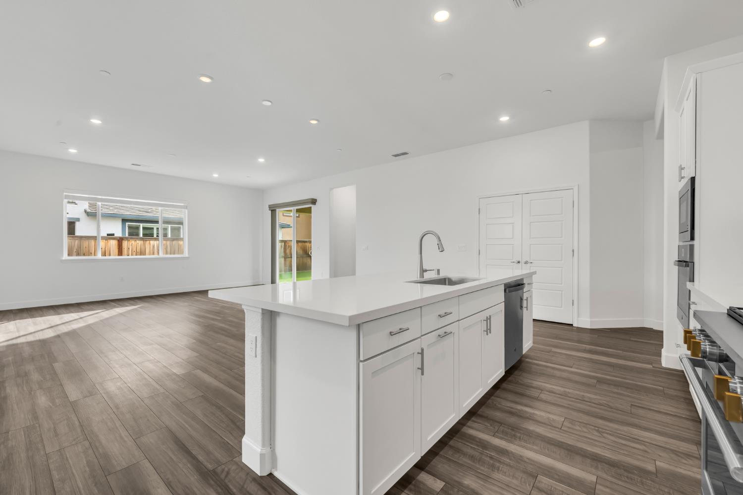 4236 Bellwether Way Sacramento, CA 95835 - Photo 11 of 46 a large kitchen with stainless steel appliances granite countertop a lot of counter space and wooden floors