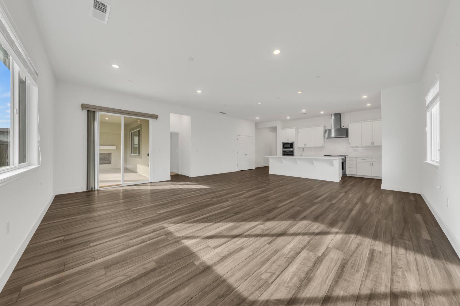 4236 Bellwether Way Sacramento, CA 95835 - Photo 13 of 46 a view of kitchen and empty room with wooden floor and windows