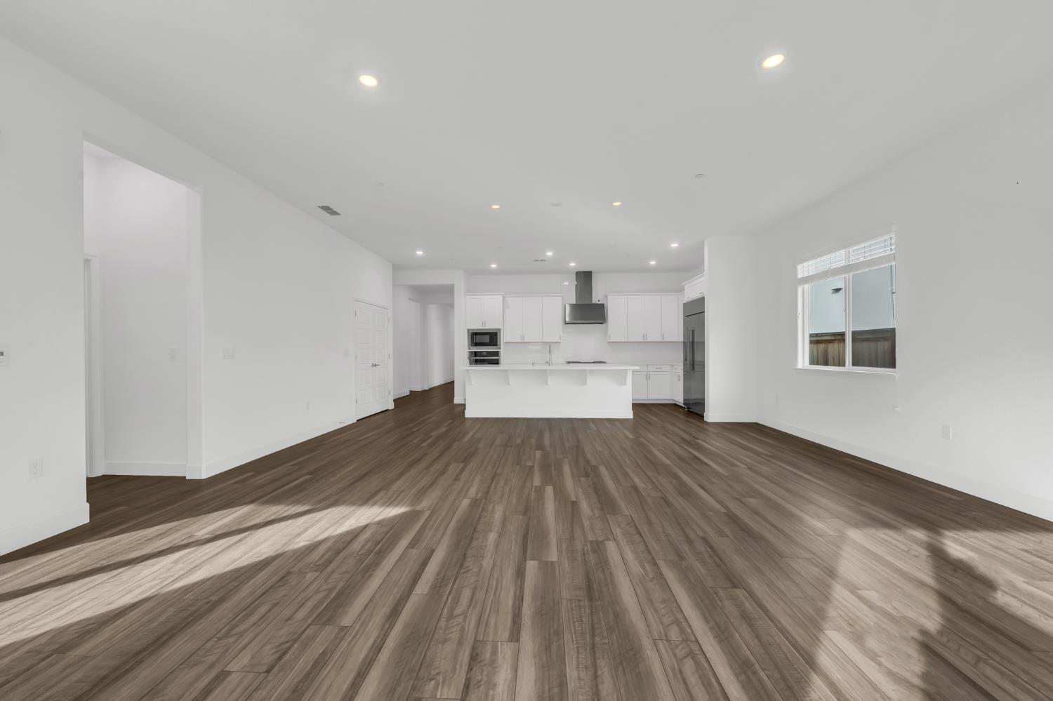 4236 Bellwether Way Sacramento, CA 95835 - Photo 15 of 46 a view of kitchen and empty room with wooden floor