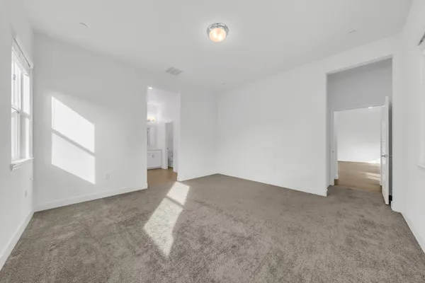 an empty room with windows and entrance to other room