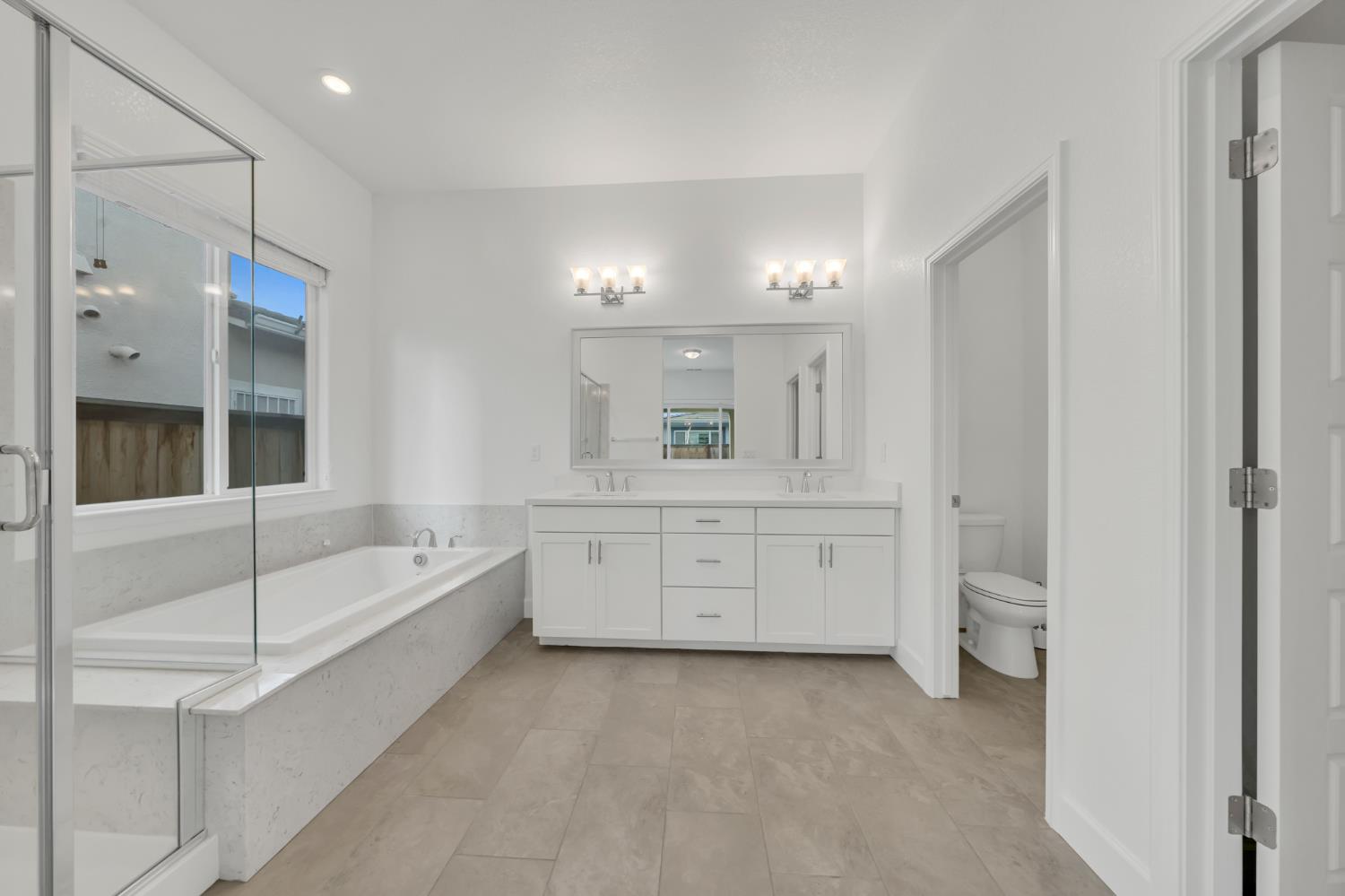 4236 Bellwether Way Sacramento, CA 95835 - Photo 20 of 46 a bathroom with a double vanity sink a toilet a mirror and shower