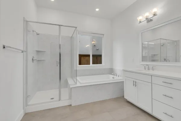 a bathroom with a bathtub a shower a sink and a window