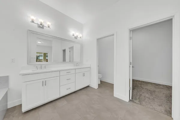 a spacious bathroom with a granite countertop sink mirror and
