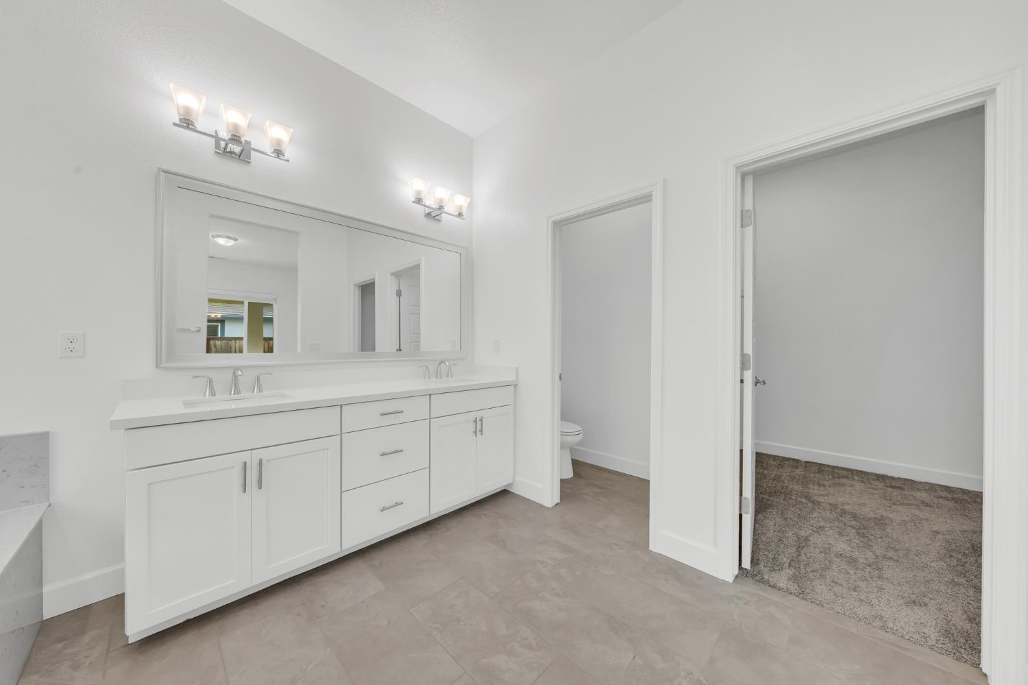 4236 Bellwether Way Sacramento, CA 95835 - Photo 22 of 46 a spacious bathroom with a granite countertop sink mirror and