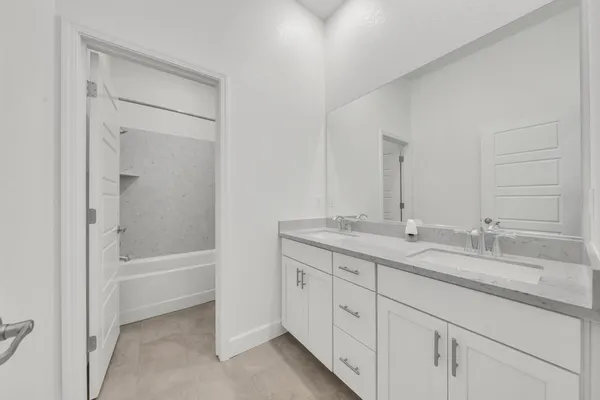 a bathroom with a granite countertop sink double and mirror