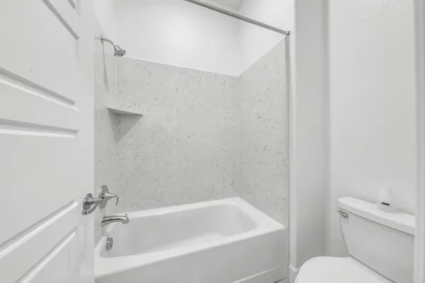 a white bath tub sitting next to a white toilet