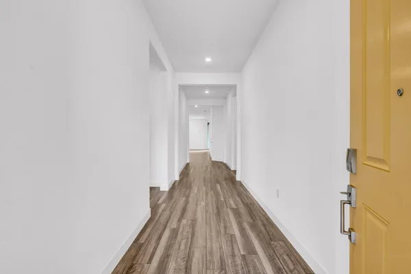 a view of a hallway with wooden floor