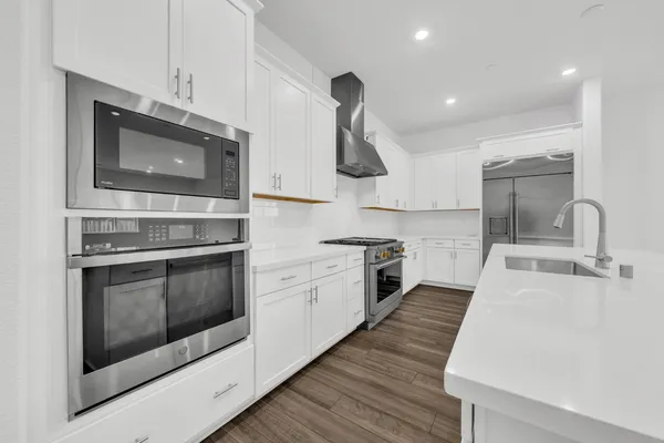 a kitchen with stainless steel appliances a stove microwave and sink