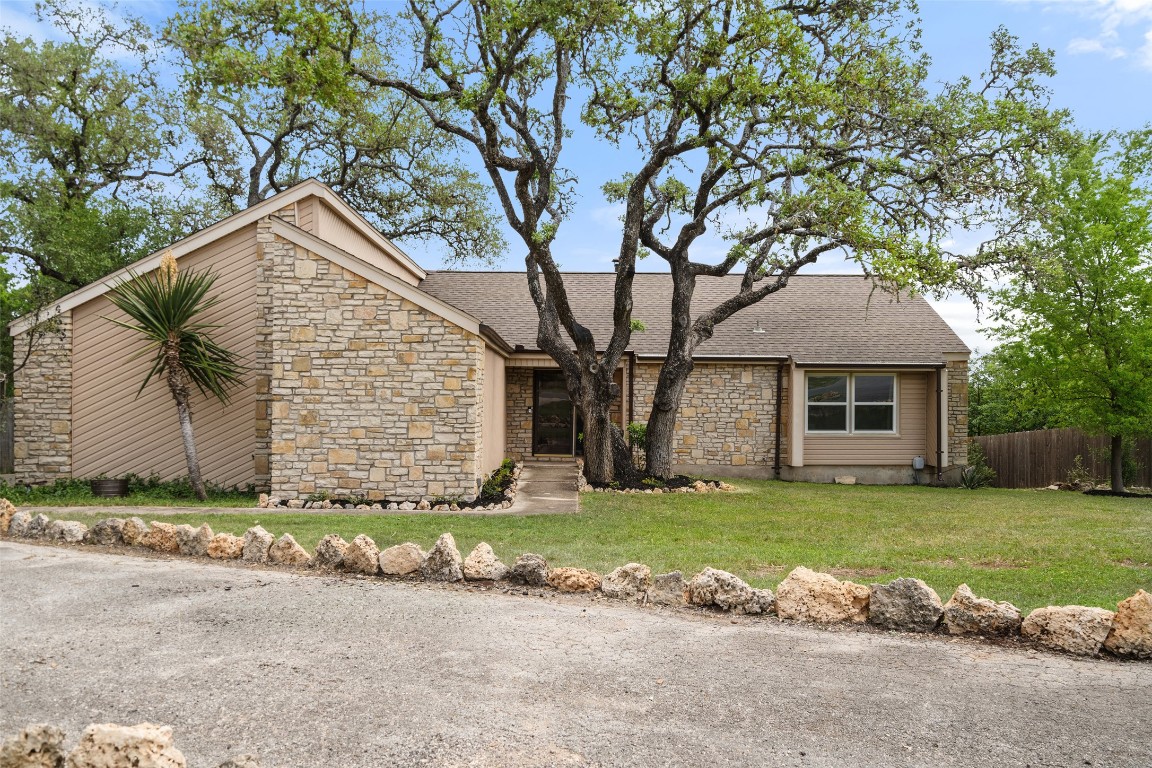a front view of a house with a garden and yard