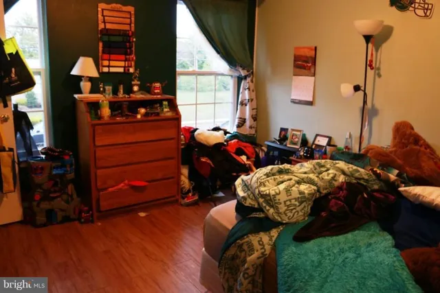 a bedroom with a bed and teddy bear on bed