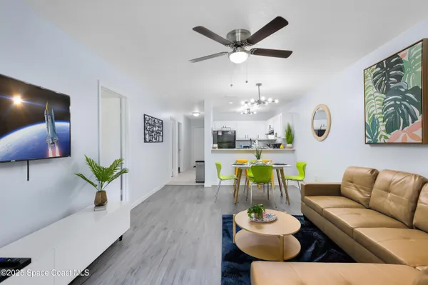 a living room with furniture and a chandelier