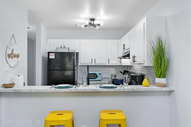 a kitchen with a refrigerator a stove and cabinets