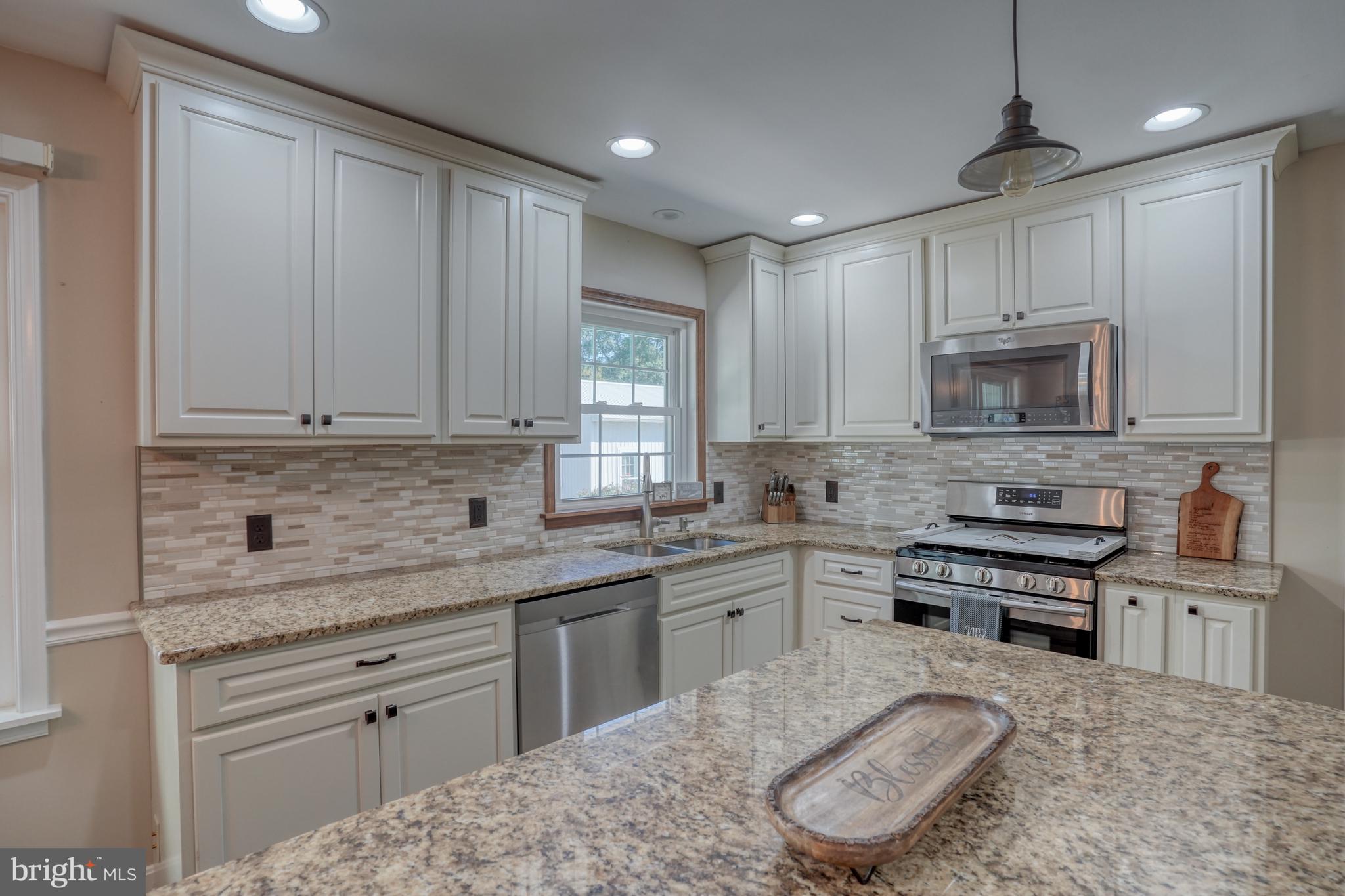 1051 Hartly Road Hartly, DE 19953 - Photo 35 of 47 a kitchen with kitchen island granite countertop a sink cabinets and stainless steel appliances