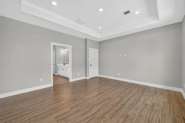 a view of an empty room with wooden floor and closet