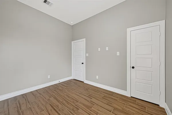 a view of an empty room with wooden floor