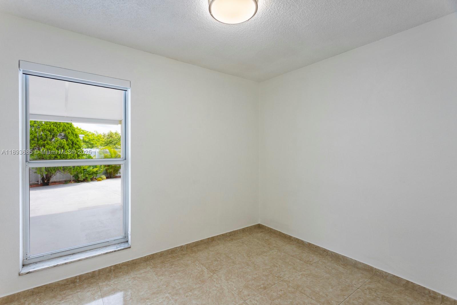 10770 Southwest 26th Street Miami, FL 33165 - Photo 18 of 35 a view of empty room with wooden floor and fan