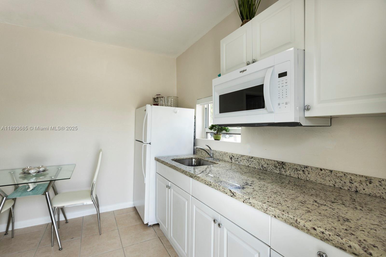 10770 Southwest 26th Street Miami, FL 33165 - Photo 25 of 35 a kitchen with stainless steel appliances granite countertop a sink and a microwave