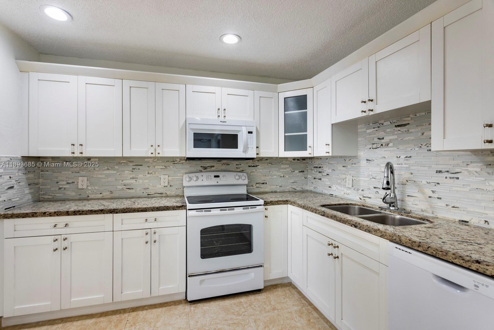 10770 Southwest 26th Street Miami, FL 33165 - Photo 9 of 35 a kitchen with granite countertop white cabinets white stainless steel appliances and a sink