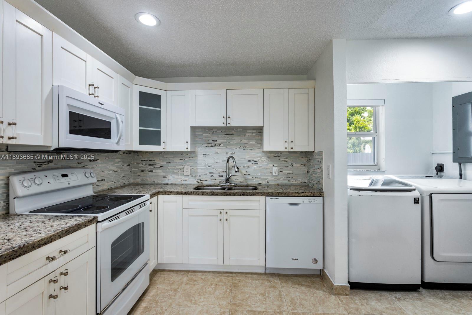 10770 Southwest 26th Street Miami, FL 33165 - Photo 10 of 35 a kitchen with granite countertop white cabinets and white appliances